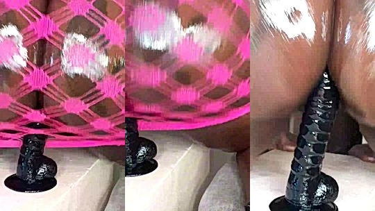 Black-minaj riding a black wall dildo from behind
